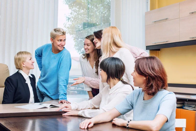 Group of women in the office at the seminar together discuss topics of interest at the table